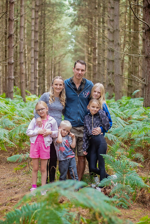 Family walking through woodland during a relaxed lifestyle photoshoot in Suffolk