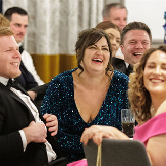 Guests laughing, reacting and enjoying live table entertainment during a formal evening event