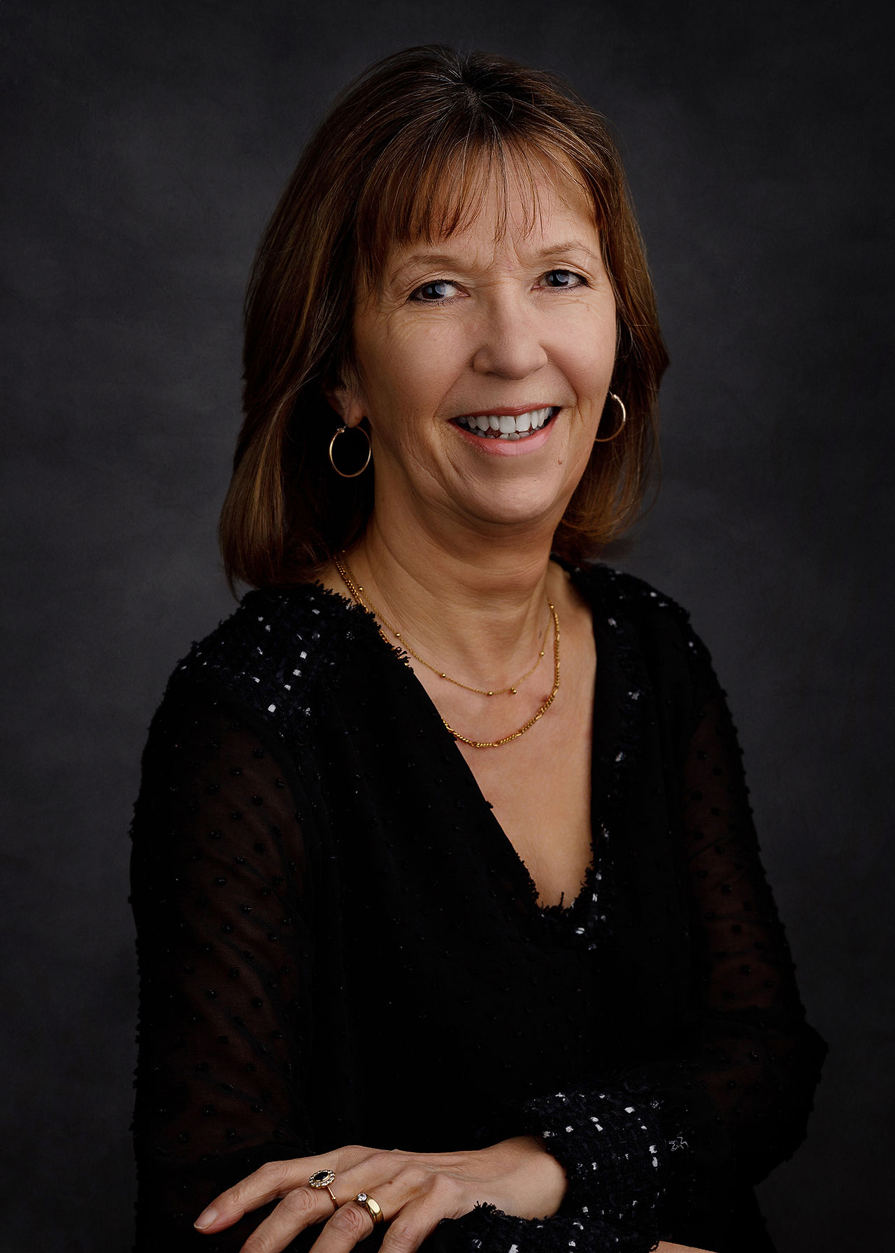 Professional studio headshot of a woman in Bristol, relaxed and approachable portrait on a dark background