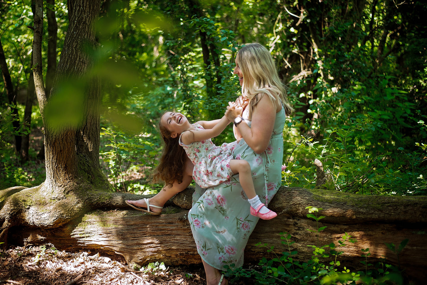 Parent lifting child in woodland during a relaxed outdoor family photoshoot