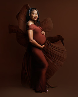 Expectant couple holding baby bump in intimate studio maternity portrait