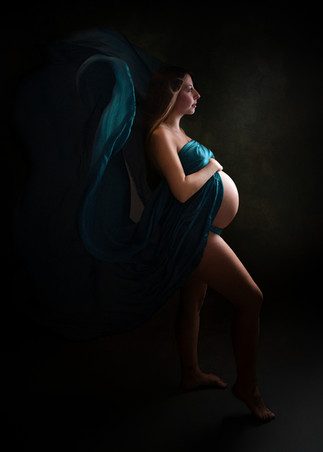 Pregnant woman in teal fabric during dramatic maternity photoshoot in Bristol