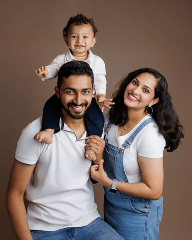 Natural studio family portrait in Portishead with parents and toddler smiling together