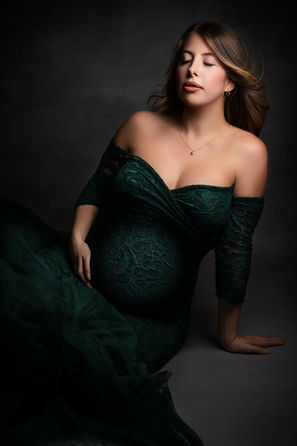 pregnant woman in dark green gown seated studio maternity photographer Bristol