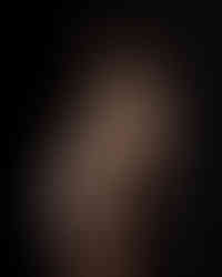 Pregnant woman in embellished nude gown during elegant studio maternity portrait