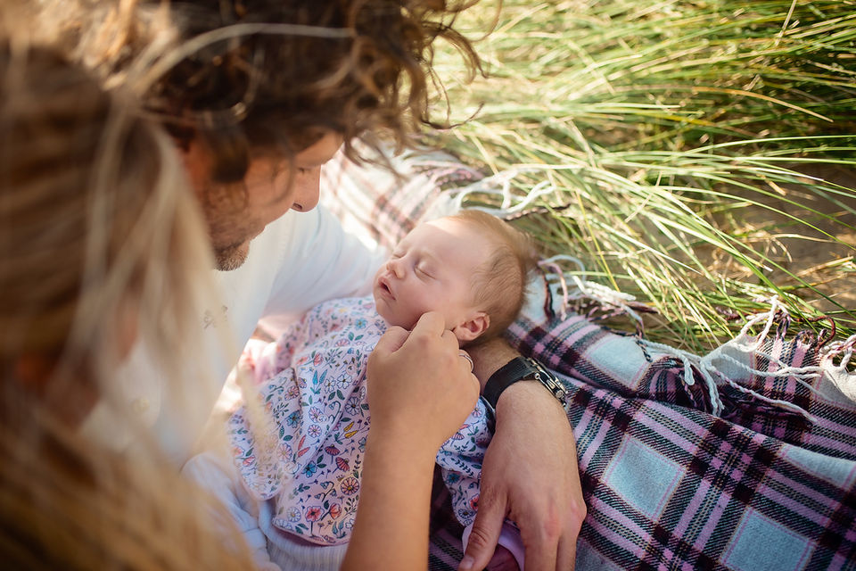Mother feeding baby during an intimate outdoor family photoshoot in Suffolk