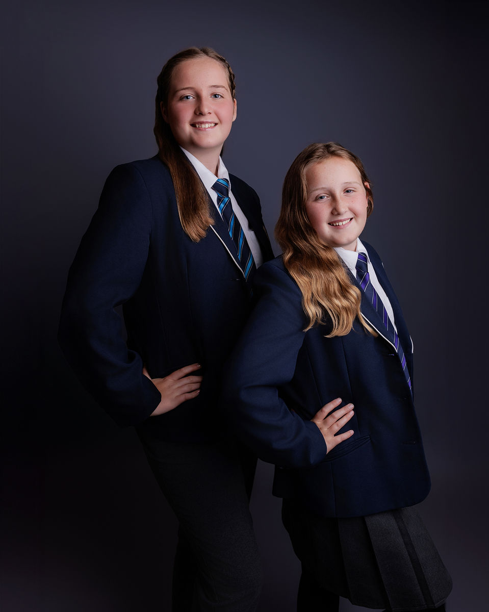 Two secondary school sisters photographed together in uniform during a studio school photography session near Bristol.