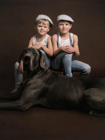 Creative studio portrait of children styled in vintage outfits with a dog, fine art composite