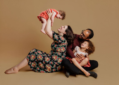 Relaxed family photo with parents and young children in studio