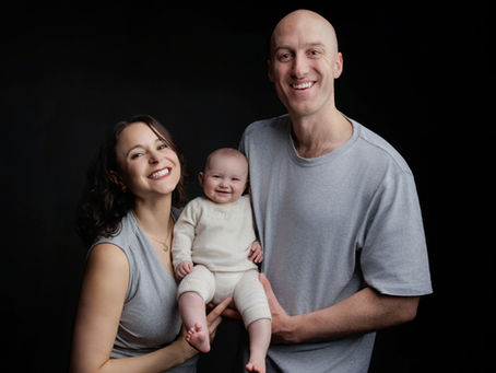 A family with a baby share a happy moment having a photoshoot in bristol