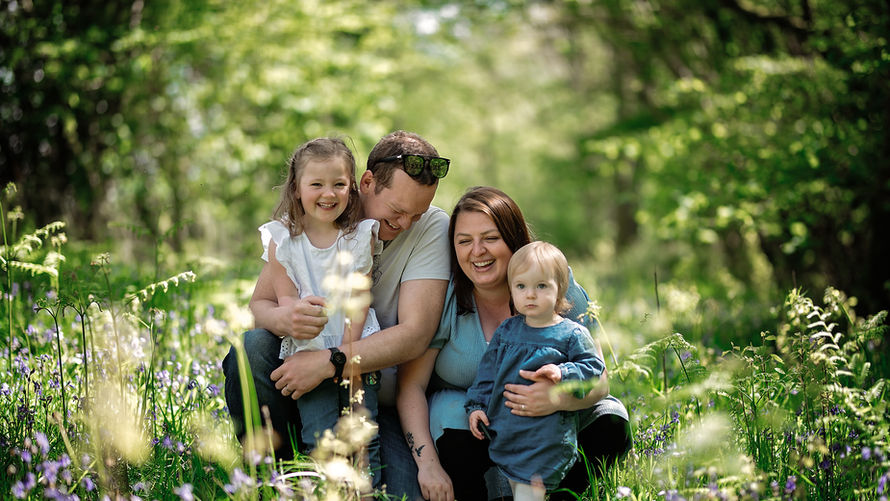 Family sitting together outdoors during a relaxed lifestyle photography session