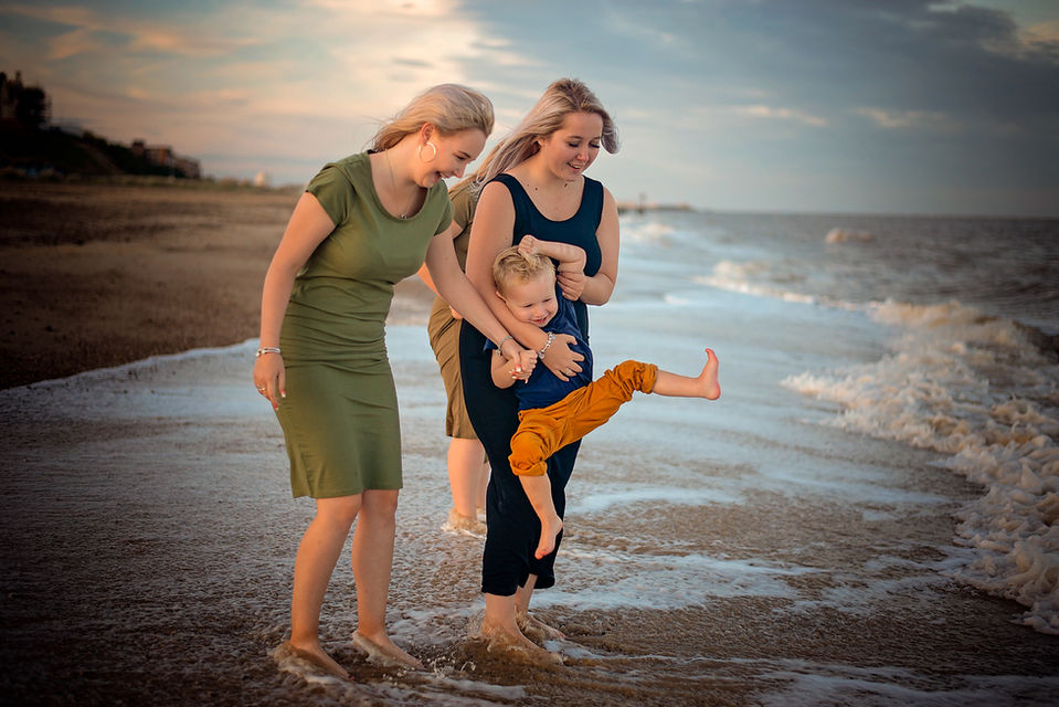 Family walking along the beach during a relaxed outdoor family photoshoot in Suffolk