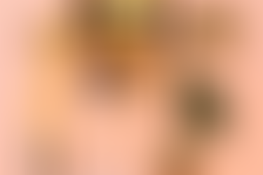 Toothbrushes, jade roller, gua sha, jar, creams, and cotton swabs on peach background. Natural skincare items neatly arranged.