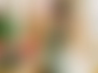 Florist in a green apron, talking on the phone, writes in a notebook. Surrounded by vibrant flowers in a bright, airy shop. Smiling mood.