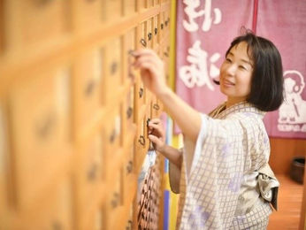 木札をさわっている着物の女性