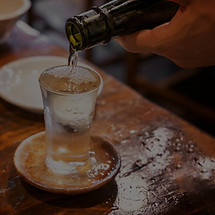 一升瓶からグラスへそそぐ日本酒