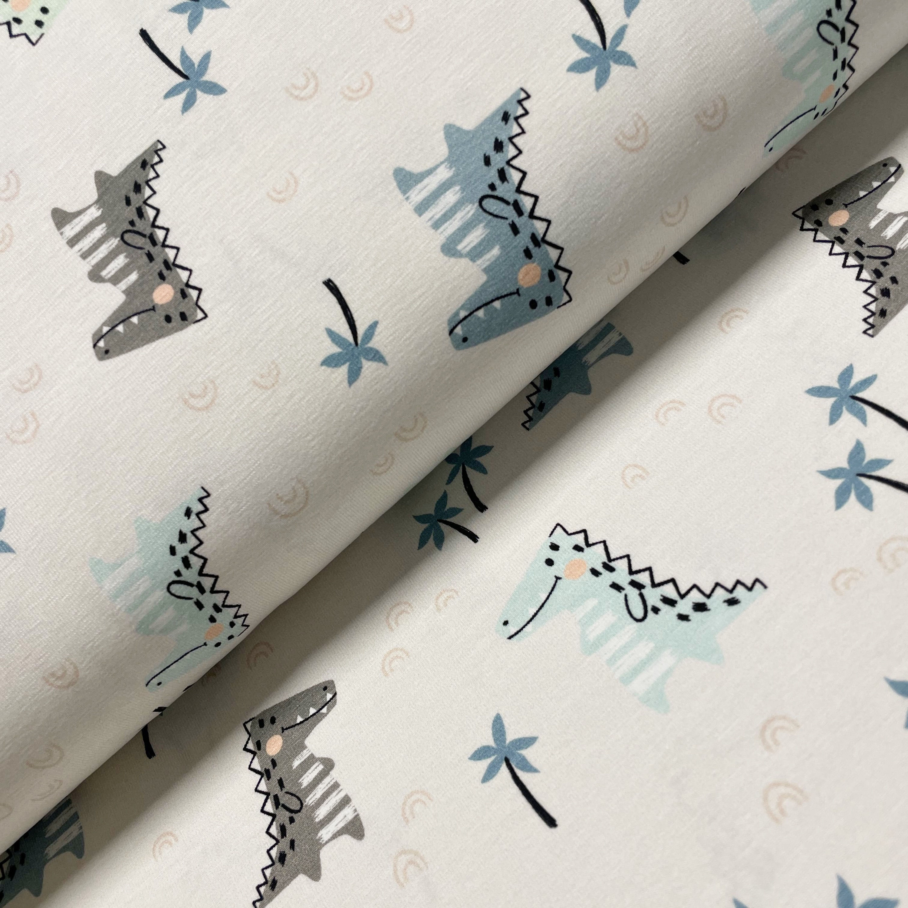 Jersey mit glücklichen Krokodilen, auf dem Stoffballen