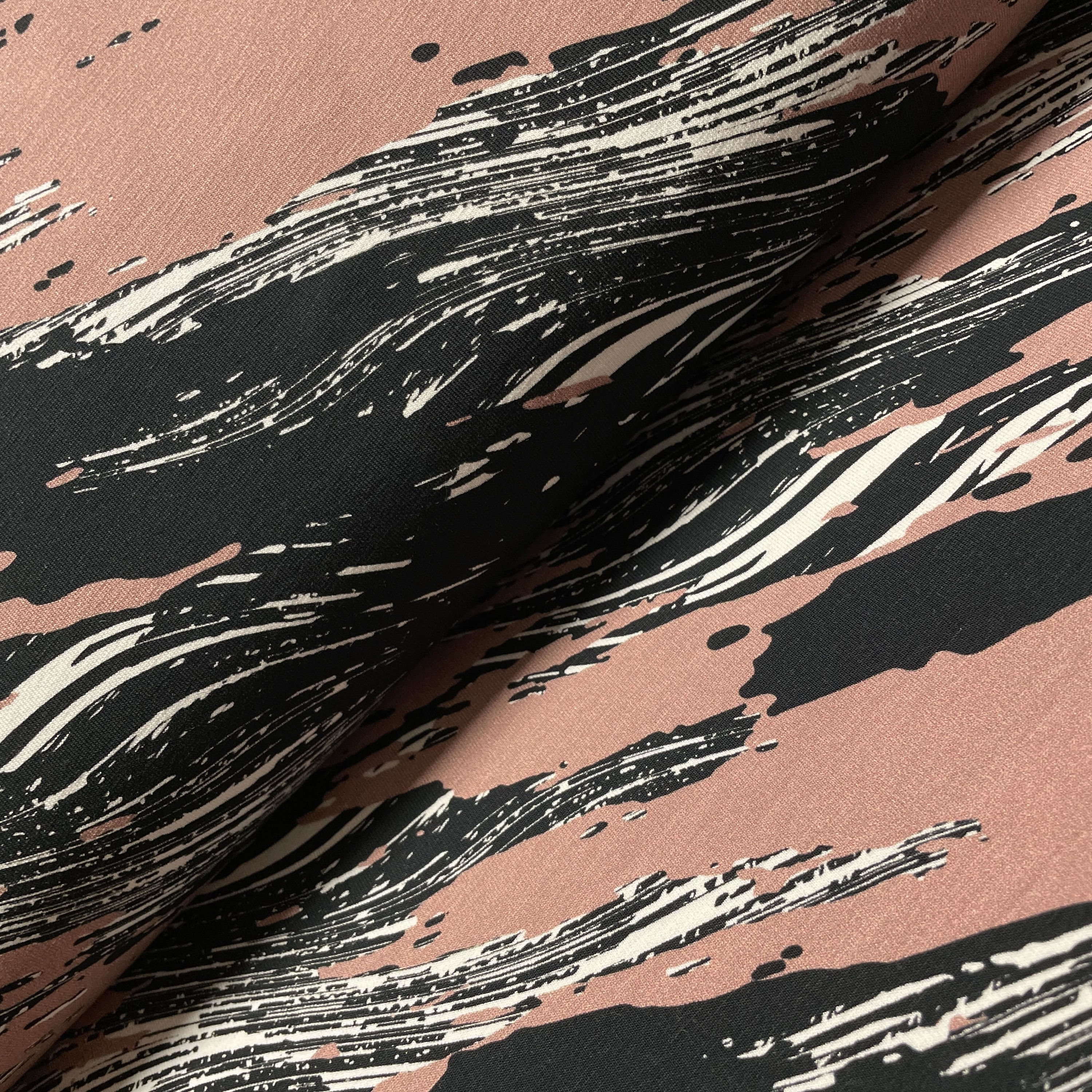 French-Terry in dusty Lachsrosa mit abstrakter Zeichnung, auf dem Stoffballen