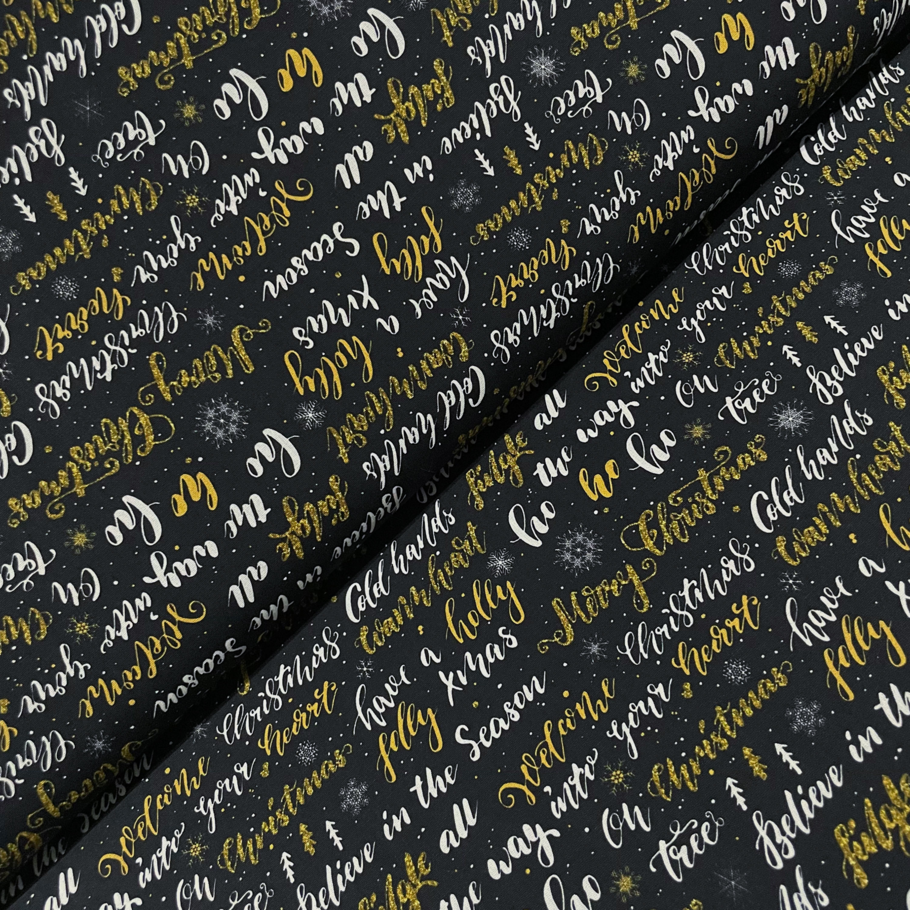 Baumwolle mit weihnachtlichen Schriftzügen, auf dem Stoffballen