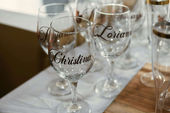 Personalized wine glasses on a table at a birthday party.