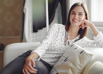 Woman seated on couch with blurred background