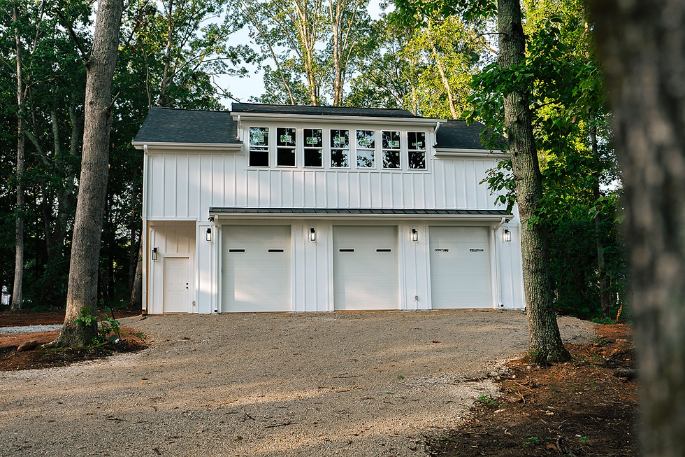 Detached garage with upper level living space designed for a wooded residential property