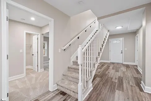 Renovated home interior with updated staircase, flooring, trim, and finishes