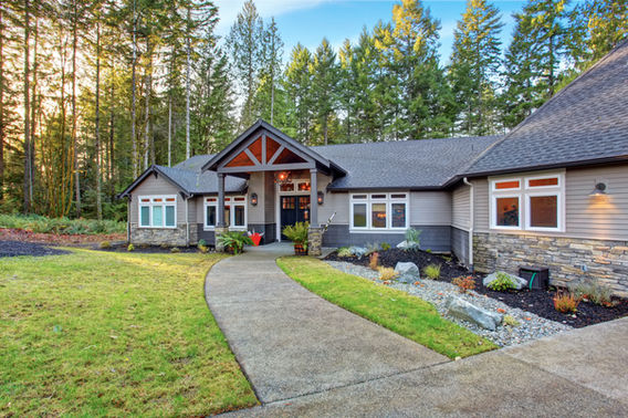 Single-family home with stone exterior, front walkway, and evergreen trees