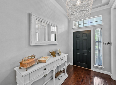 Bright home entryway with black front door and white console table