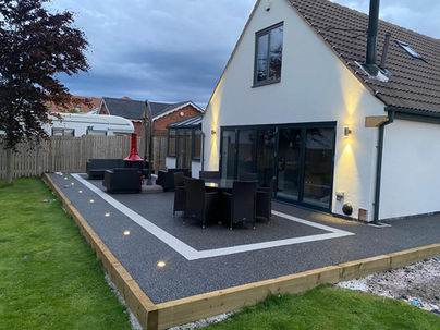 side view of patio at the back of a property with lights on