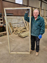man stood with a wooden door frame
