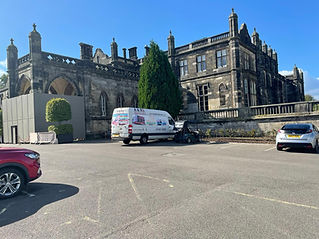 van in front of large estate 