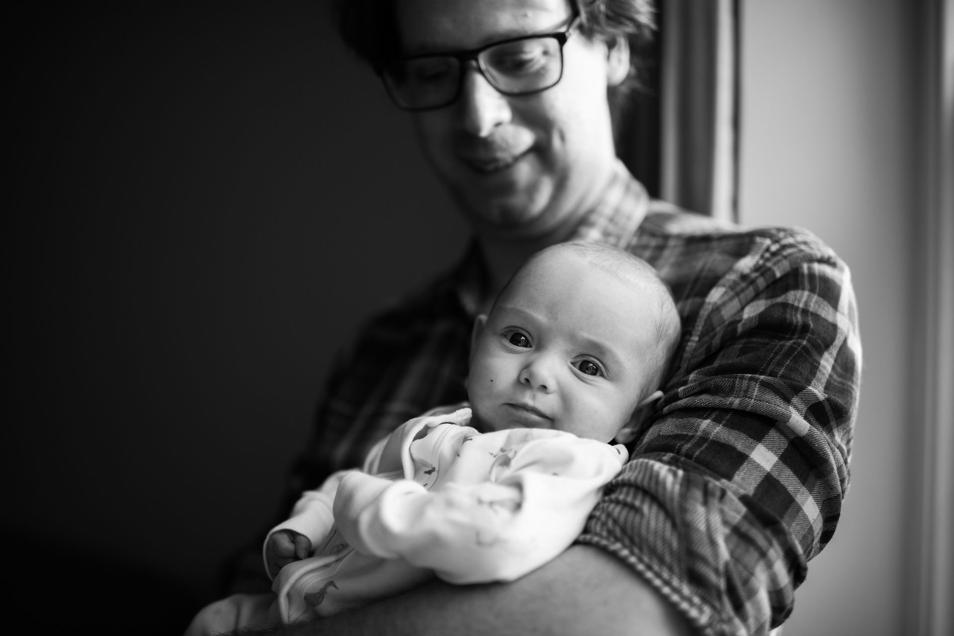 black and white image of dad holding baby | newborn photography newcastle | Angela Fenwick Photography