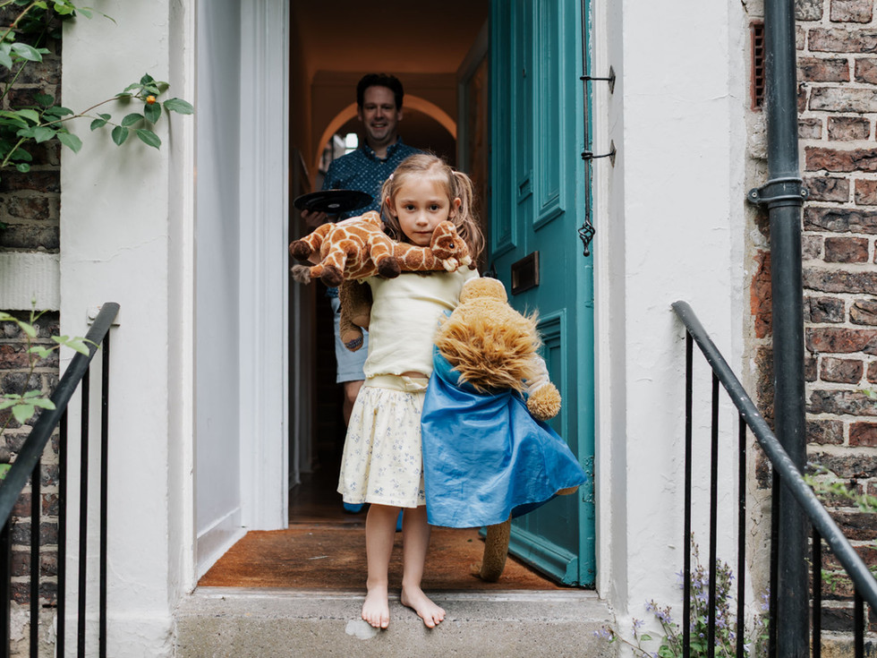little girl in doorway holding soft toys | family photography Newcastle | Angela Fenwick Photography