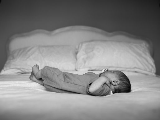 black and white image of newborn baby lying at the bottom of a bed | newborn photoshoot Newcastle | Angela Fenwick Photography