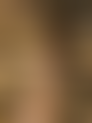 Eine Frau mit langen, braunen Haaren steht auf einer Wiese vor einer Eiche. Sie trägt ein Sommerkleid, die Arme hängen herunter , sie hat die Augen geschlossen und sieht entspannt aus.- Gedanken stoppen und Grübeln beenden