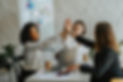women working together at a business meeting. high fiving and celebrating profit growth