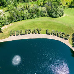 Holiday Lakes spelled in hedges beside a lake