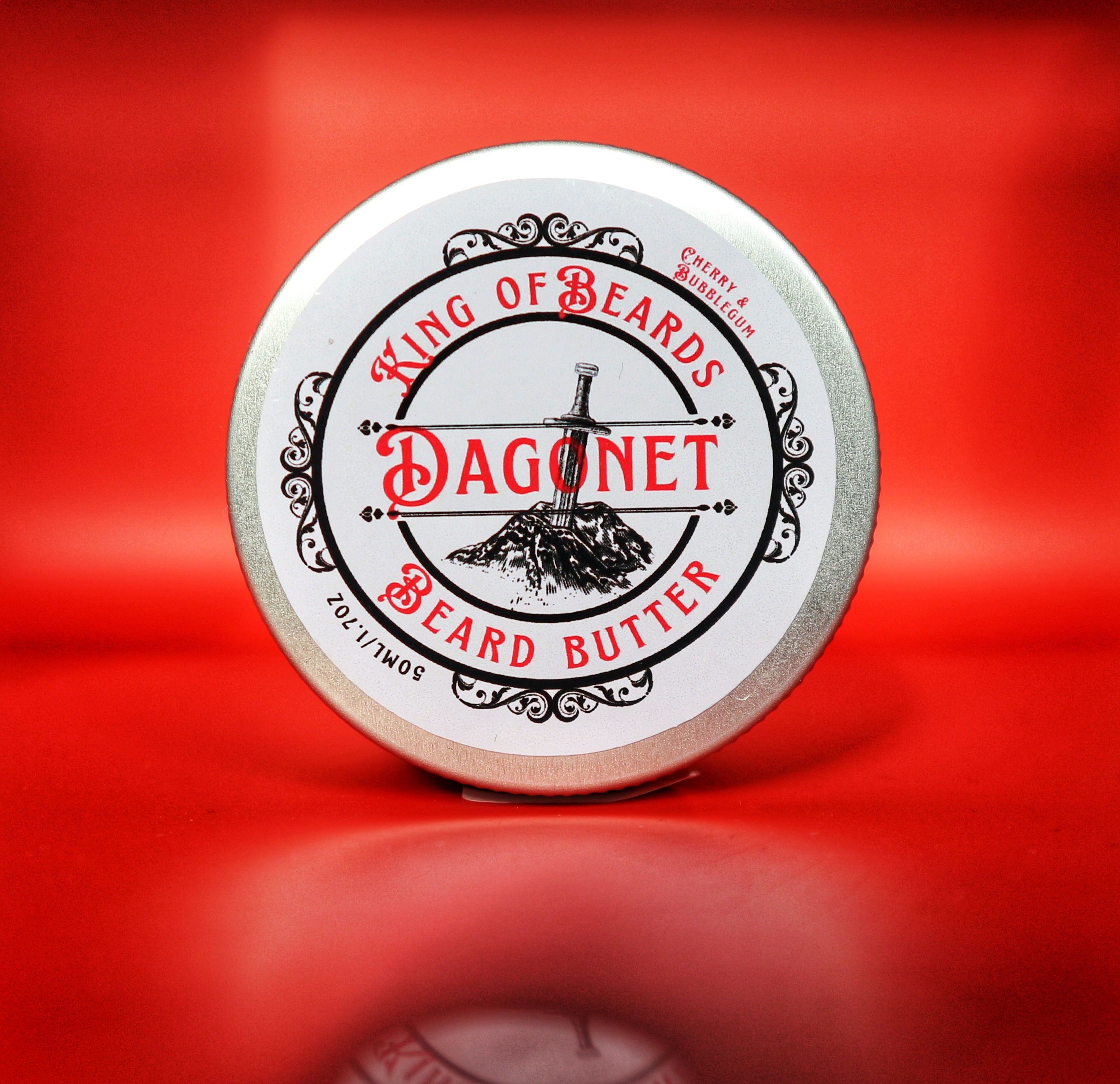 King of Beards Dagonet Beard Butter tin with red text and sword logo on a rich red background.