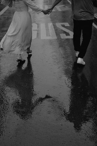 Couple walking on rainy street reflection New York City engagement