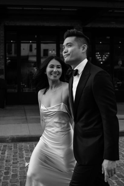 Black-and-white portrait of couple embracing on a cobblestone street in the Meatpacking District, bride in silk slip dress looking up at groom, NYC wedding