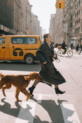 Woman crossing New York City street with dog personal session