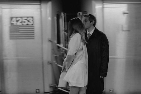 Black and white wedding couple kissing on NYC subway train