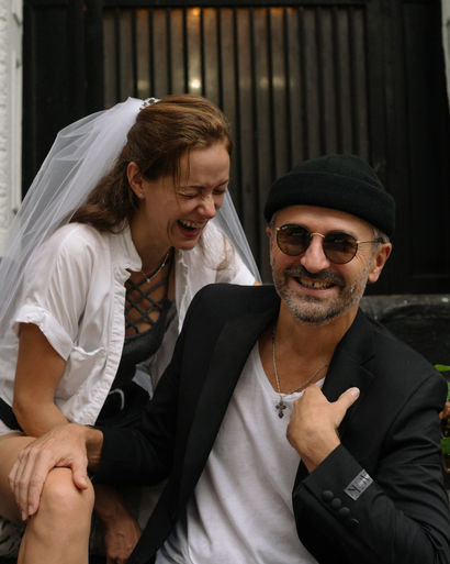 Candid moment of couple laughing together on a graffiti staircase, bride in veil and white t-shirt, NYC