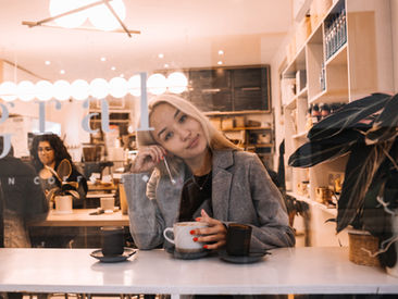 Portrait of a woman in a grey blazer sitting with a coffee cup at Café Integral in SoHo, New York City