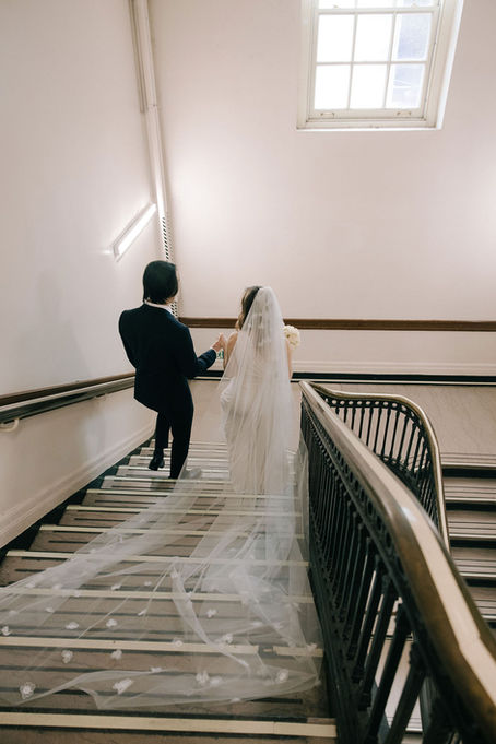 Bride with cathedral veil on staircase Staten Island Borough Hall New York City