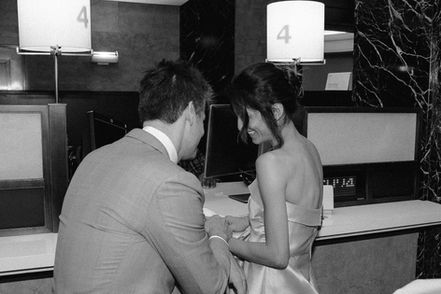 Black-and-white photo of couple sharing an intimate moment inside NYC City Hall during their wedding ceremony