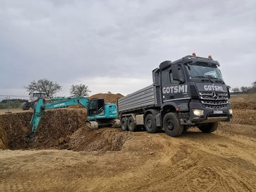 Aushubarbeiten mit Bagger und LKW auf einer Erdbau-Baustelle