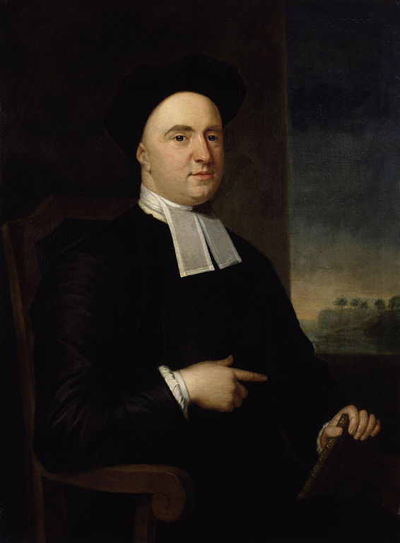 Hombre vestido de negro con cuello blanco, sentado en una silla. Fondo oscuro con paisaje claro a la derecha. Mira al frente con expresión seria.