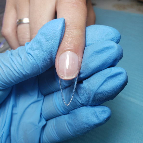 Uñas en soft gel terminadas: tips preformados pegados sobre la uña natural, con acabado liviano